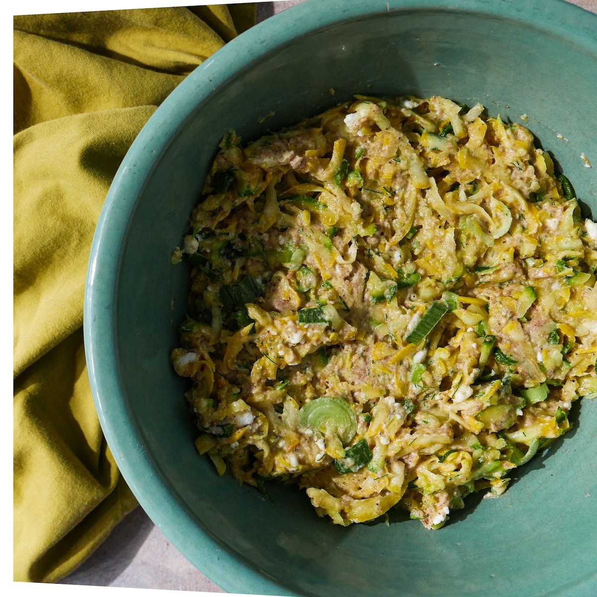 fritter-batter.jpg Mixing zucchini fritter batter together in a bowl.