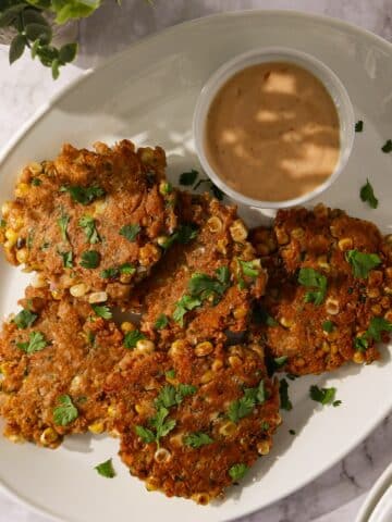 Crispy corn fritters with jalapeño on a plate.