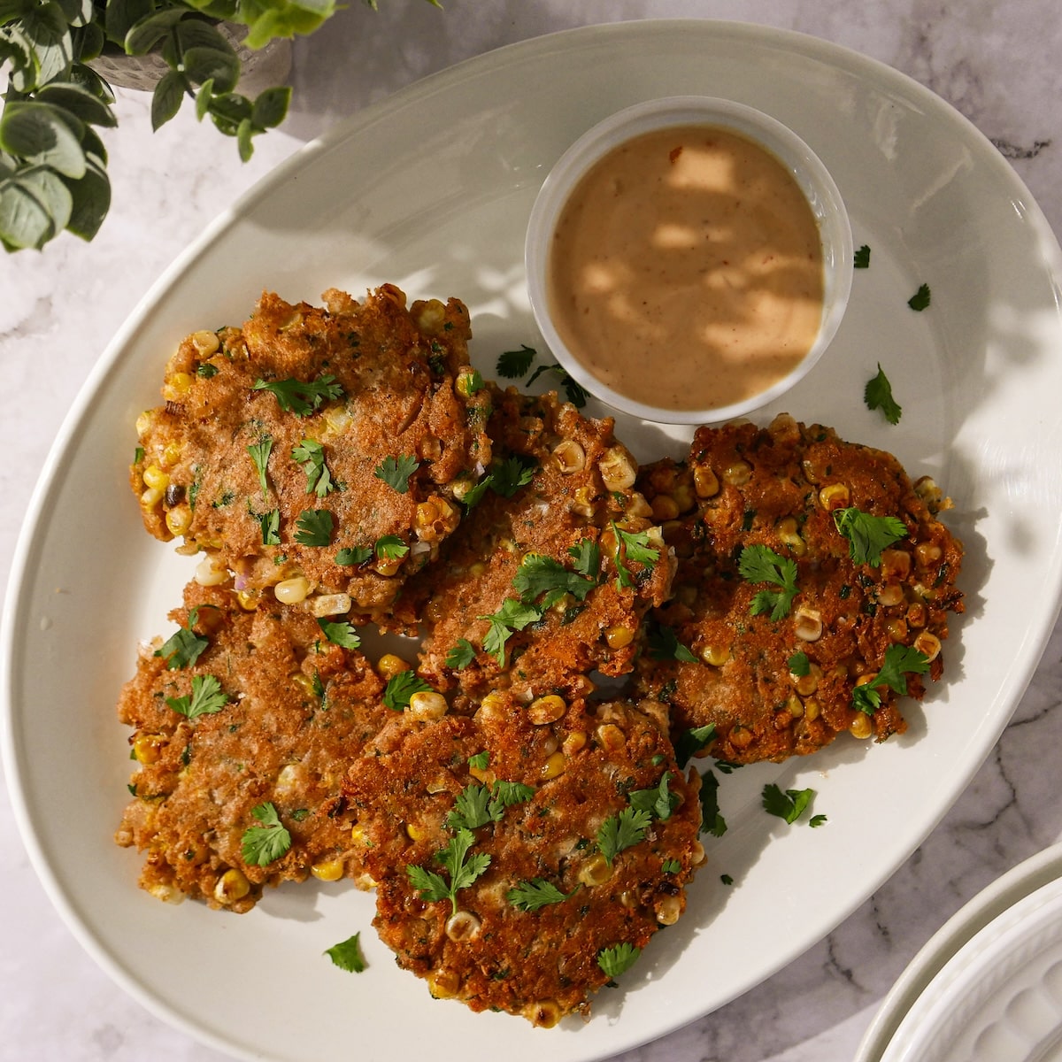 Crispy corn fritters with jalapeño on a plate.